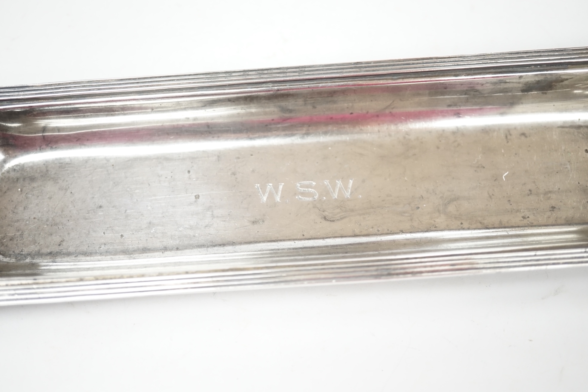 A George V silver rectangular inkstand, with two mounted glass wells and pen recess, John Grinsell & Sons, Birmingham, 1910, length 35.4cm, stand 7.2oz. Condition - fair to good